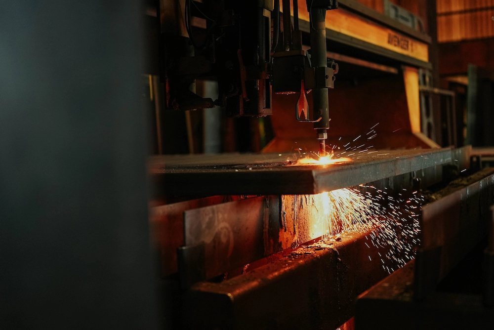 Flame cutting torch slicing through thick steel plate