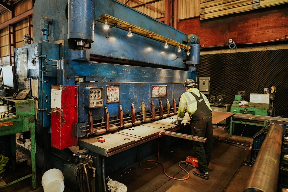Metal sheet being sheared by industrial machine